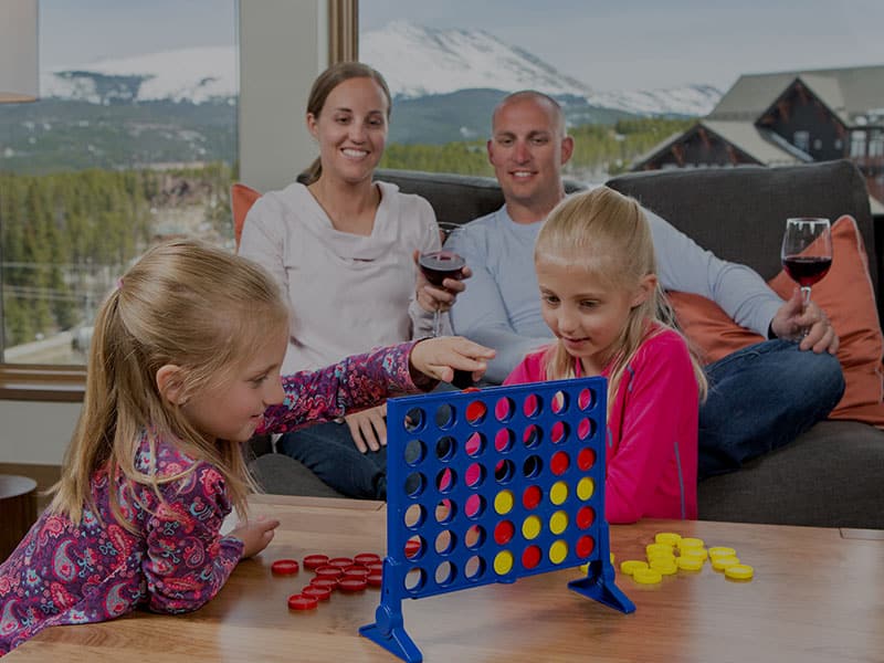 Kids playing Connect 4 while Parents watch